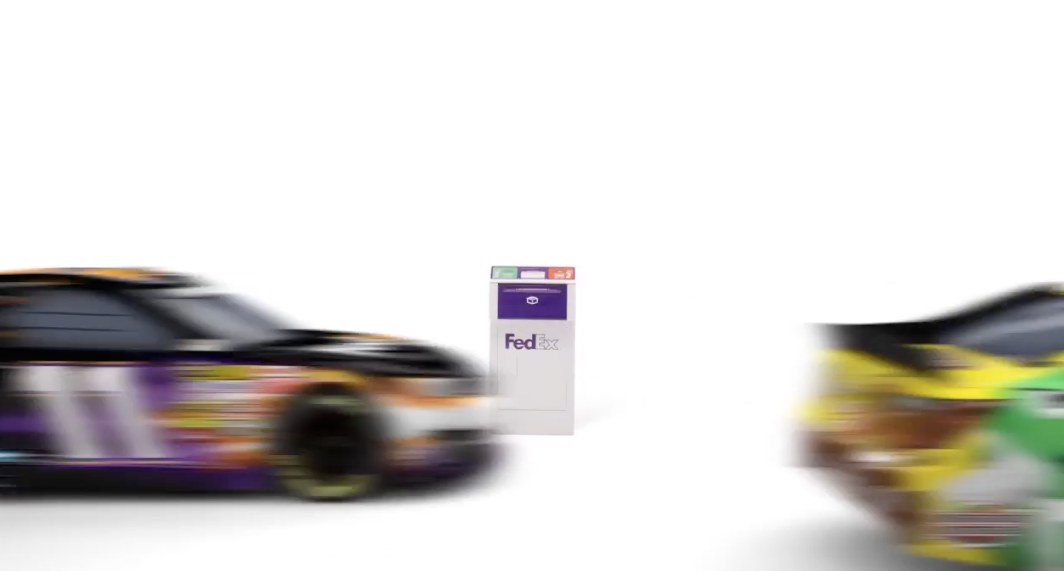 Race cars speeding past a FedEx Drop Box